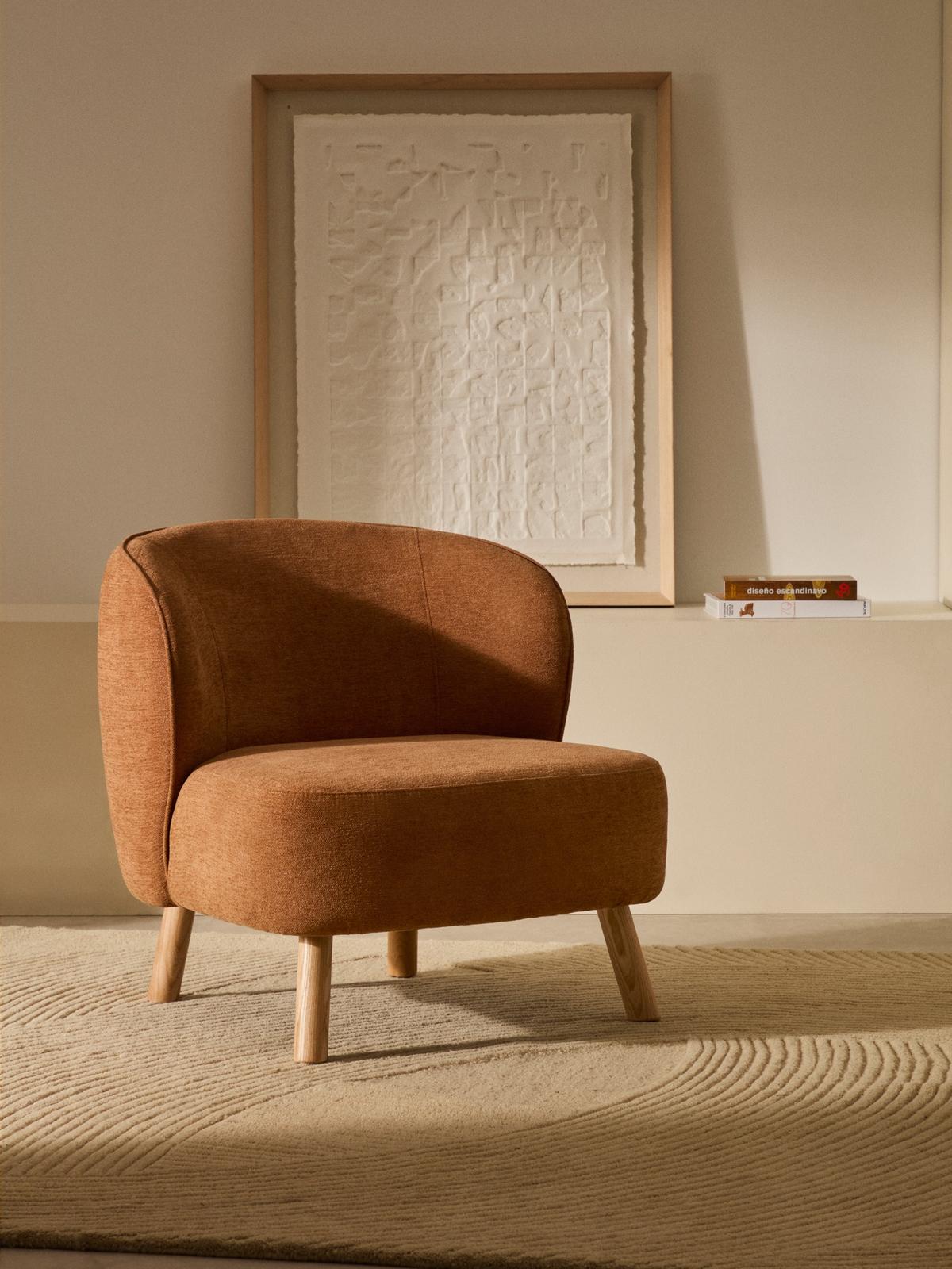 Fauteuil Ulit in terracotta chenille met massief beukenhouten poten natuurlijke afwerking.